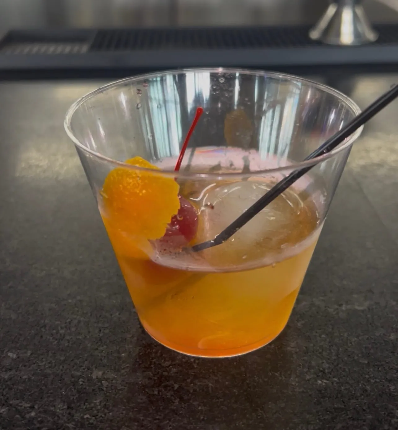 A cocktail served with orange peel