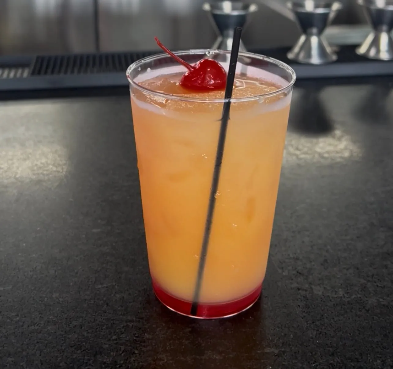 A cocktail over ice with a cherry