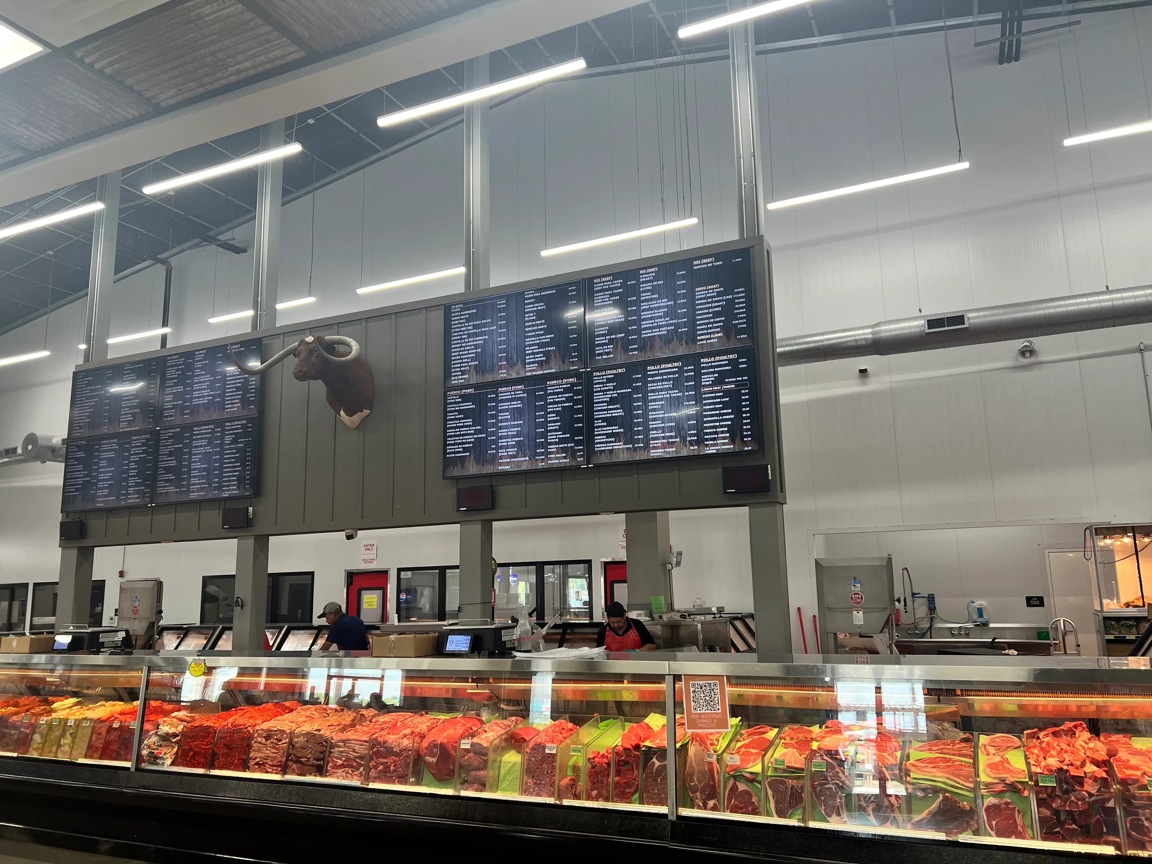 The meat counter under the price boards, with the longhorn above it